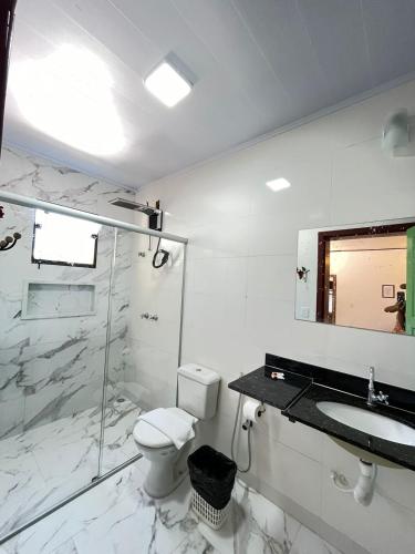 uma casa de banho com um WC, um lavatório e um chuveiro em Pousada Sesmaria em Lavras Novas