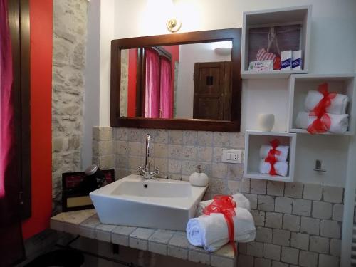 uma casa de banho com lavatório, espelho e toalhas em Relais Cà del rio em Botteghino di Zocca