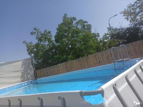 una piscina junto a una valla de madera en פנינת יוחאי-הצימר הזוגי, en Bar Yohai