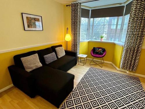 a living room with a black couch and a window at Central Brighton Pavilion Pad. in Brighton & Hove
