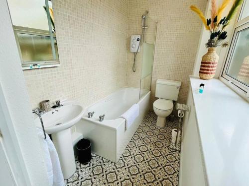 a bathroom with a tub and a toilet and a sink at Central Brighton Pavilion Pad. in Brighton & Hove