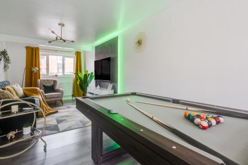a living room with a pool table with balls on it at Spacious 5 BR Home Nr Etihad Stadium with Pool Table in Manchester