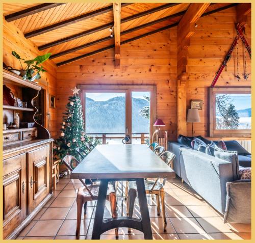 une salle à manger avec une table et un sapin de Noël dans l'établissement Sublime I Chalet T5 I Les Gets, aux Gets