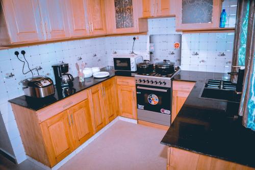 a kitchen with wooden cabinets and a stove top oven at Hadeb Property in Bukoba