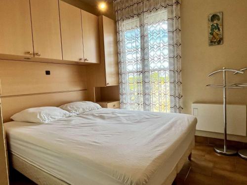 une chambre avec un lit blanc avec une fenêtre dans l'établissement Appartement 2 pièces, accès plage, parking, 4 couchages - Argelès-sur-Mer - FR-1-225-101, à Argelès-sur-Mer