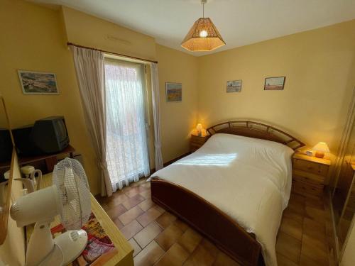 a bedroom with a bed and a tv and a window at 4SOM23 Appartement proche centre-ville in Collioure