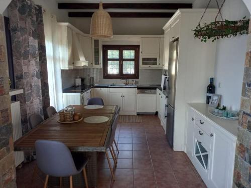 a kitchen with a wooden table and a dining room at The Villea Cottage - 5 bed house in Alli Meria in Álli Meriá