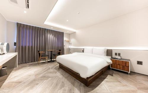 a hotel room with a bed and a table at H Avenue Gyeongju Bulkuk temple in Gyeongju