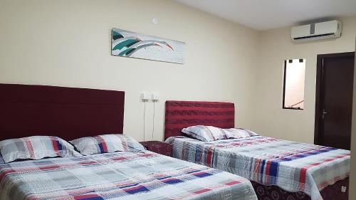 dos camas sentadas una al lado de la otra en una habitación en España Confort 2, en Ciudad del Este