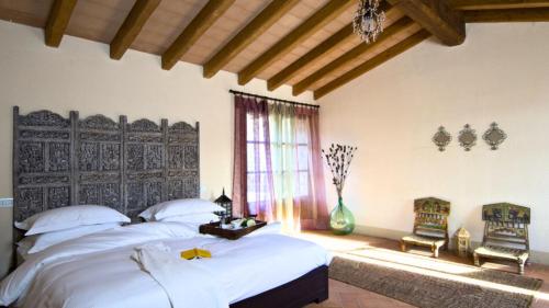 a bedroom with a large bed and two chairs at Hotel Podere Conti in Filattiera