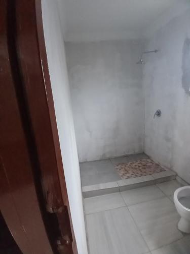 a small bathroom with a toilet and a shower at Partulaka Rest Inn in Maun