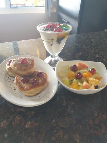 two plates of pastries and a bowl of fruit on a table at SeyBreeze Villa in Anse Royale