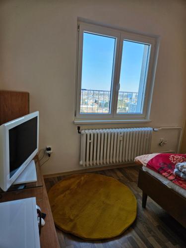 a living room with a large window and a tv at Tererka apartment in Olomouc