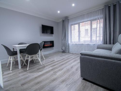 a living room with a couch and a table and chairs at City Walk Apts in Dublin