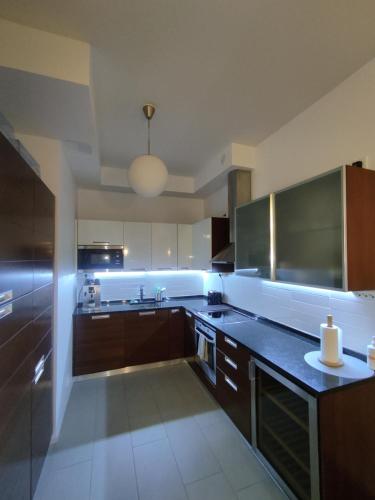 a large kitchen with brown cabinets and a sink at A luxurious aprtm with a sauna and terrace Netflix in Helsinki