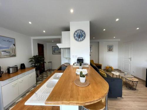 a kitchen with a table and a clock on a wall at Bourgois in Boulogne-sur-Mer