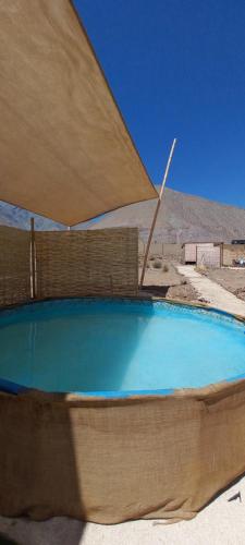 a large swimming pool with a large umbrella at Campo de Cielo Mamalluca Valle de Elqui in Vicuña