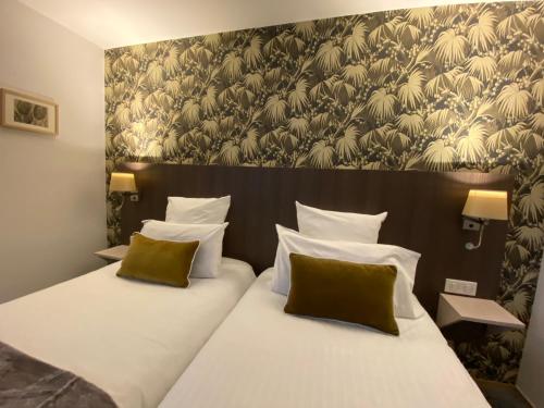 a hotel room with two beds and a large wall at Cit'Hotel Hôtel de France et d'Europe in Concarneau