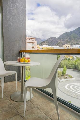 a table and chairs on a balcony with a view at Hotel Benahoare in Los Llanos de Aridane