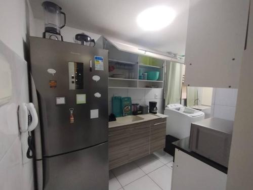 a kitchen with a stainless steel refrigerator and a sink at Cantinho da Ju in Ipojuca