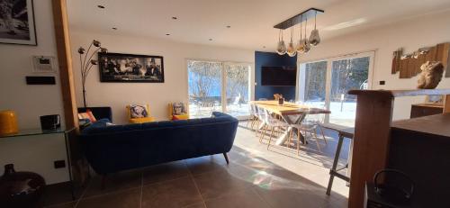 a living room with a blue couch and a table at La cabane des écureuils in Xonrupt-Longemer
