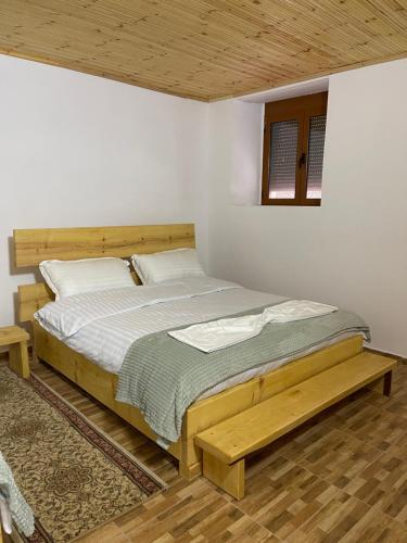 1 dormitorio con 1 cama con marco de madera en Ardjon House en Berat