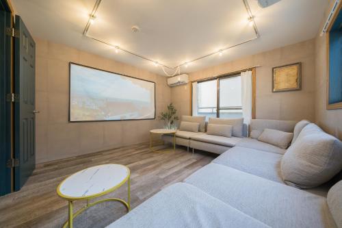a living room with a couch and a large screen at 2 shower rooms #Shinjuku 5 min walk from station ,projector in Tokyo