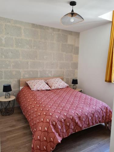 ein Schlafzimmer mit einem rosa Bett mit zwei Kissen darauf in der Unterkunft Saumur centre : appartement entièrement rénové. in Saumur