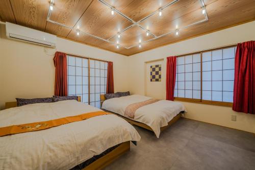 two beds in a room with two windows at Shinjuku / 5 min walk from station ※ projector in Tokyo