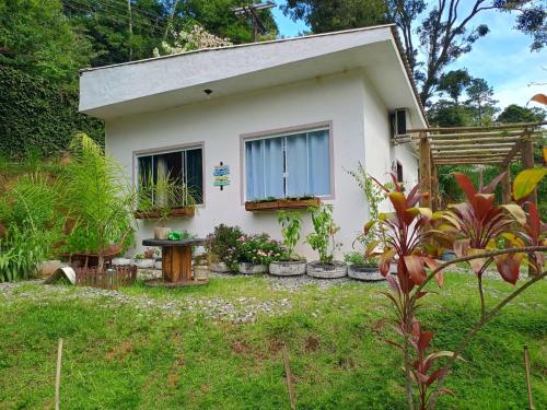 a small white house with a table in the yard at Paz e descanso Chacara Meu Morrinho in Mairiporã