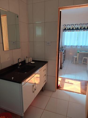 a bathroom with a sink and a door to a room at Paz e descanso Chacara Meu Morrinho in Mairiporã