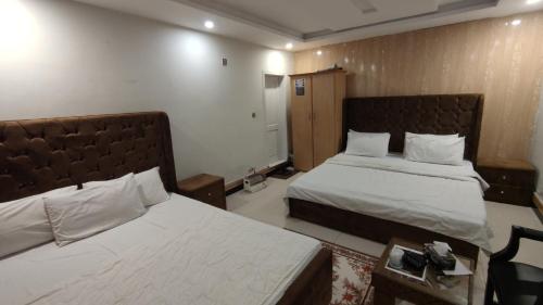 a hotel room with two beds and a table at Sunrise Rest House in Islamabad