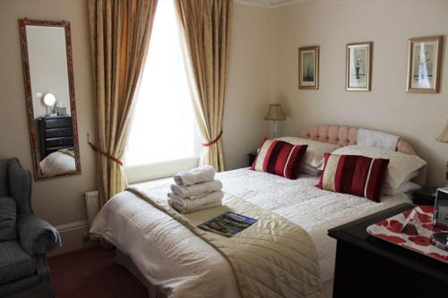 a bedroom with a large bed with towels on it at Three Gables in Bridlington