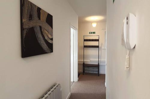 a hallway with a phone hanging on a wall at May Sale!! 2-Bed Apartment Town centre Train Station Wi-Fi in Colchester