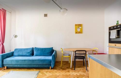 ワルシャワにあるCozy Apartment Pragaのリビングルーム(青いソファ、テーブル付)