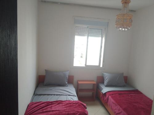 twee bedden in een kamer met een raam bij Appartement in Casablanca close to the beach in Casablanca