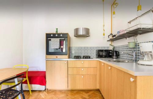 cocina con armarios de madera y microondas en Cozy Apartment Praga, en Varsovia