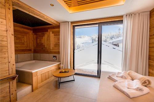 eine Sauna mit einer Badewanne und einem Tisch mit Handtüchern in der Unterkunft Alpin Peaks in Turracher Hohe