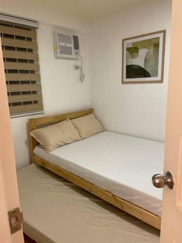 een klein bed in een kamer met een raam bij Casa Teresita: 1Br Unit @ Arezzo in Davao City