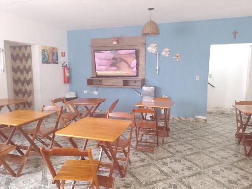 カラグアタトゥーバにあるPousada Sandramarのテーブルと壁掛けテレビ付きの部屋