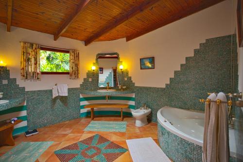 een badkamer met een bad en een wastafel bij Coté Sud - Unique Villa & Bungalows Intendance Road in Takamaka