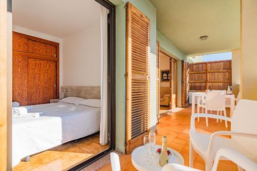 um quarto com uma cama, uma mesa e cadeiras em Apartamentos Bressol em Port de Pollensa