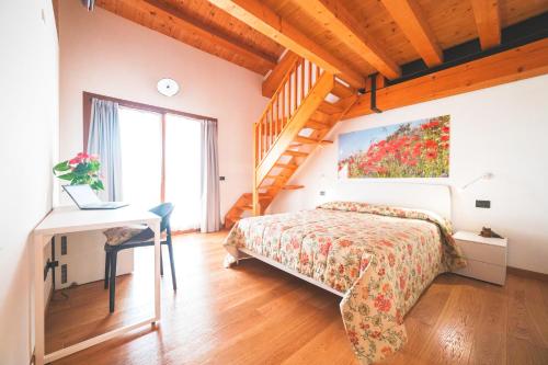 a bedroom with a bed in a room with a staircase at Col Delle Rane in Caerano di San Marco