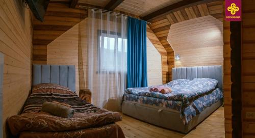 ヴェルホヴィナにあるКарпатське Щастяのベッド1台とソファが備わる小さな客室です。