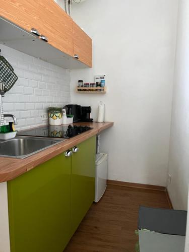 een keuken met een groene wastafel bij LOGICO #35 HOME in Bari