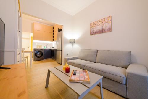 ein Wohnzimmer mit einem Sofa und einem Tisch in der Unterkunft New modern 2nd floor apartment in Thessaloniki