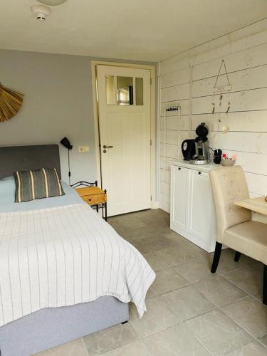 1 dormitorio con cama, mesa y cocina en By Onzz en Kamperland