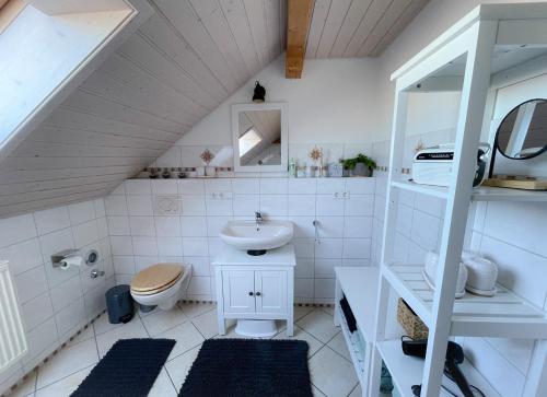 a white bathroom with a sink and a toilet at Ferienwohnung Hintermoos in Kißlegg