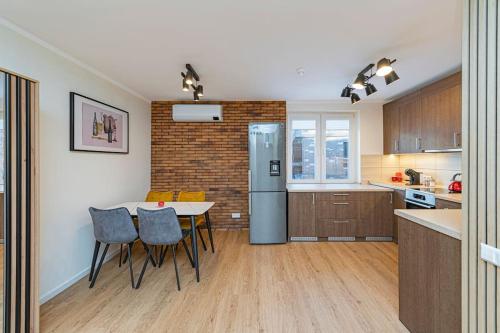 a kitchen with a table and chairs and a refrigerator at Riverfront 1BD Old Town Apartment by Hostlovers in Kaunas
