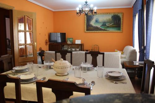 un comedor con una mesa con platos y platos en La Cuadra, en Cabornera